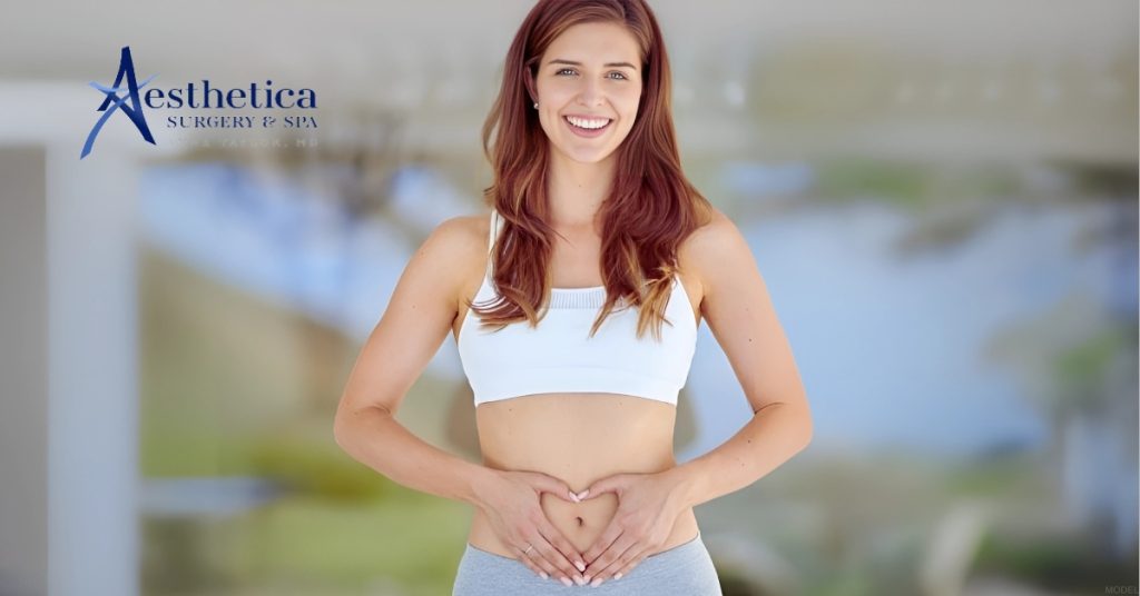 Woman holding her hands in the shape of a heart on her stomach (model)