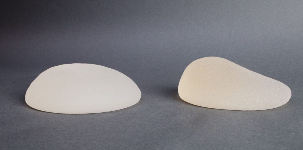 Side-by-side breast implants, with teh round implant on the left and the teardrop or anatomical implant on the right.