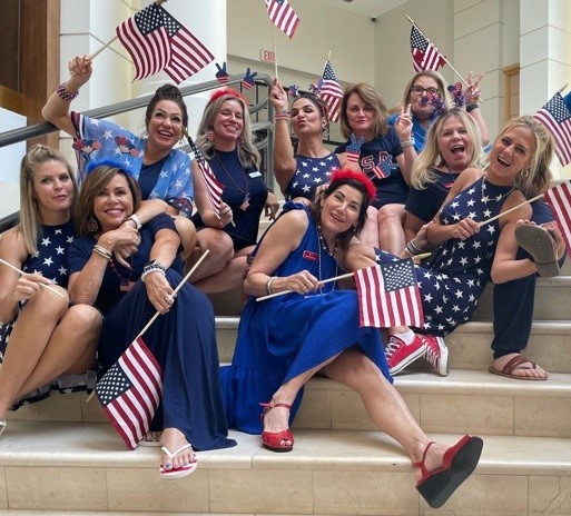 Aesthetica Surgery & Spa staff group photo of everyone wearing blue and holding American flags.