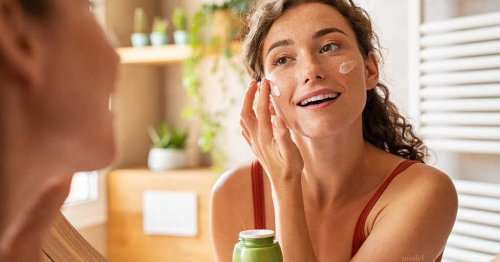 woman putting moisturizer on your face (model)